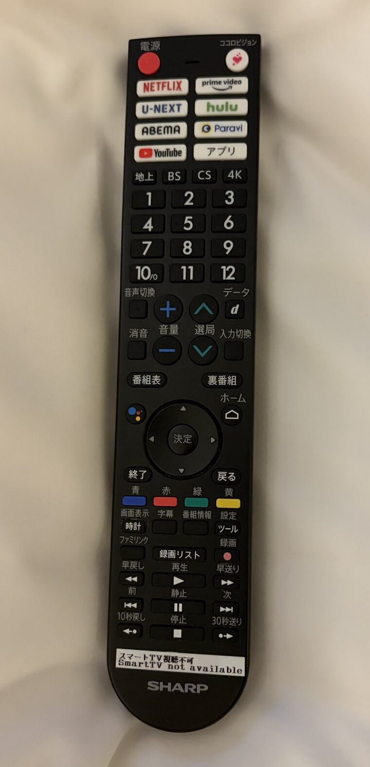 KOKO HOTEL Premier 熊本の客室テレビリモコン。「スマートTV視聴不可」という注意書きのテプラシールが貼られている様子