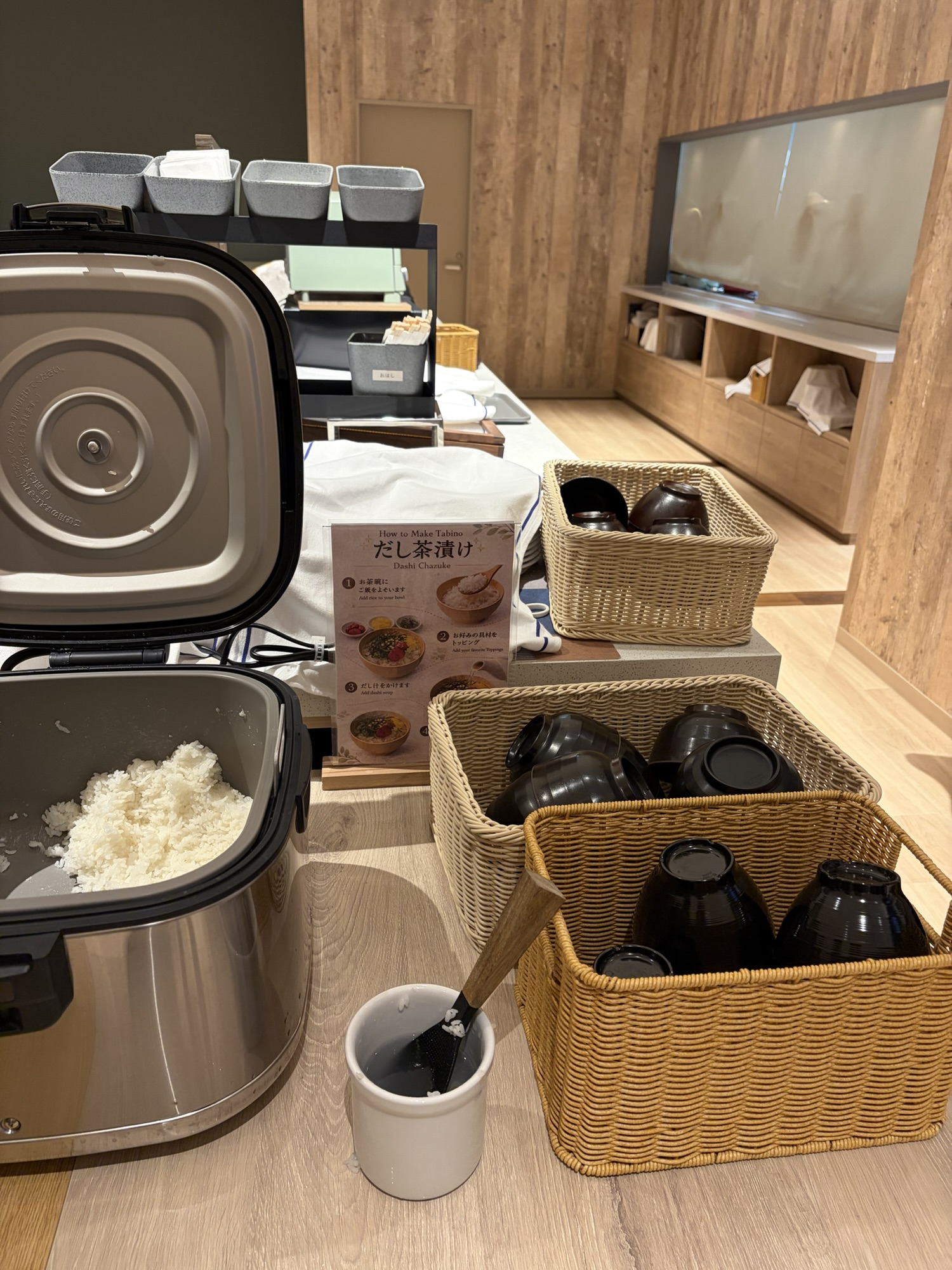 たびのホテル阿蘇熊本空港の大人気サービス「だし茶漬け」の提供コーナー。炊飯器のご飯とお椀が用意されており、自分でよそうセルフスタイルです。