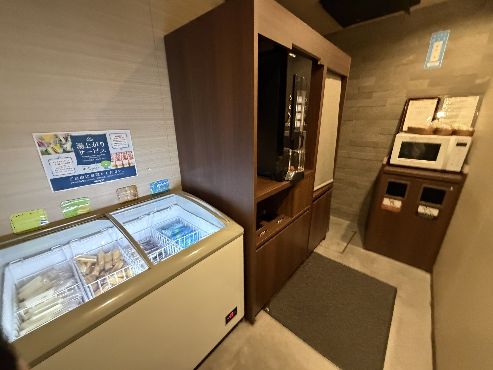 14階湯上がり処の無料アイス専用冷凍庫と、奥に設置された電子レンジ・給茶機。