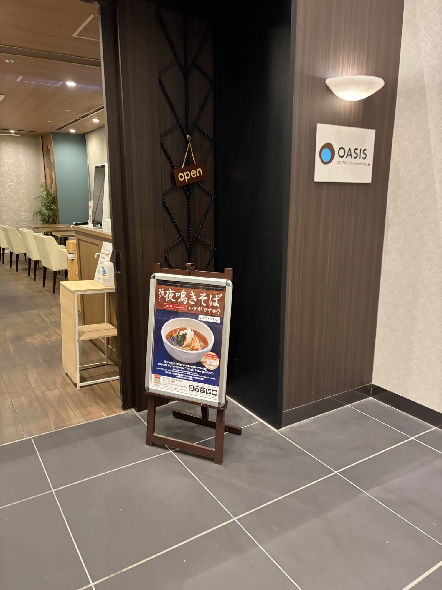 1階レストラン「OASIS」の入口と夜鳴きそば案内看板。21:30〜23:00まで無料で提供されています。