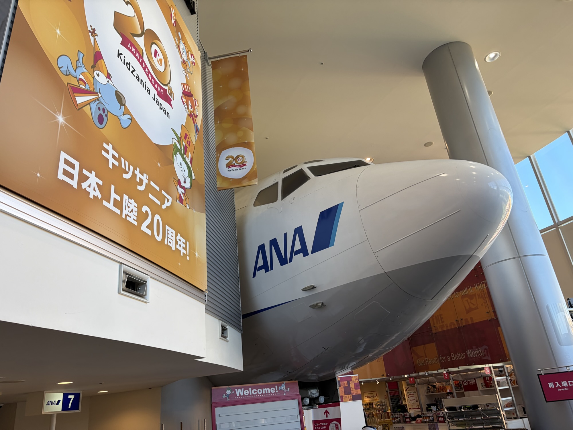 キッザニア甲子園の入場口。ANAの飛行機（機首モニュメント）と「キッザニア日本上陸20周年！」の記念看板。