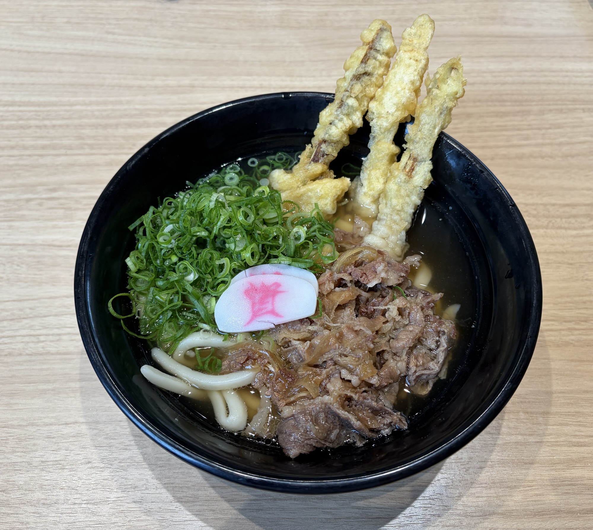 資さんうどん名物の肉ごぼ天3本うどん。甘辛い牛肉とサクサクのスティックごぼ天、無料トッピングのネギ多め
